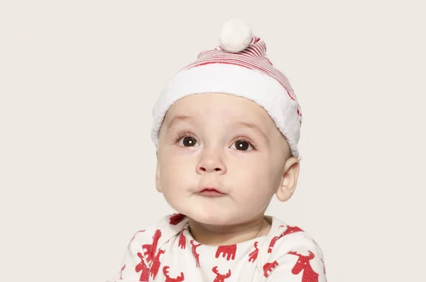Portret ładny chłopczyk patrząc myślenia w kapeluszu Santa. — Zdjęcie stockowe