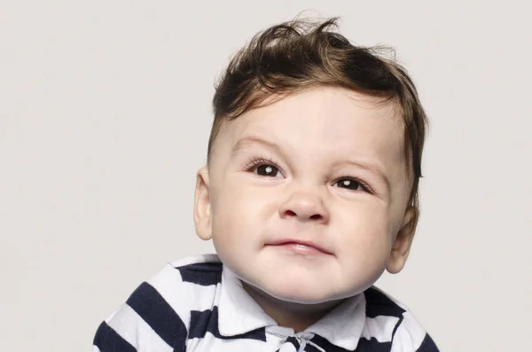 Portrait d'un bébé garçon mignon regardant vers le haut faisant des visages mignons . — Photo
