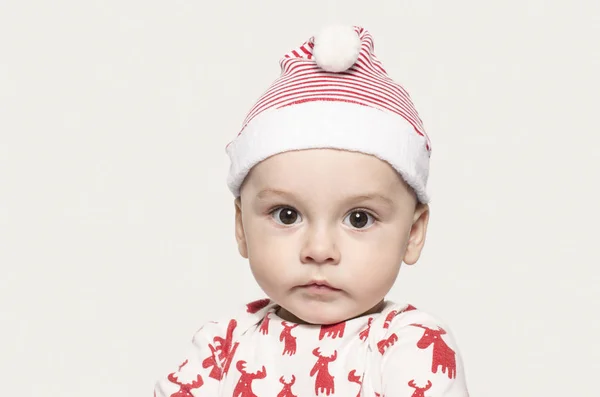 Noel Baba şapkası giyen kameraya bakarak bir şirin bebek çocuk portresi. - Stok İmaj