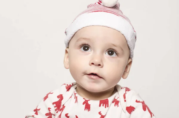 Noel Baba şapkası giyen düşünerek arıyorsunuz bir şirin bebek çocuk portresi. Stok Fotoğraf