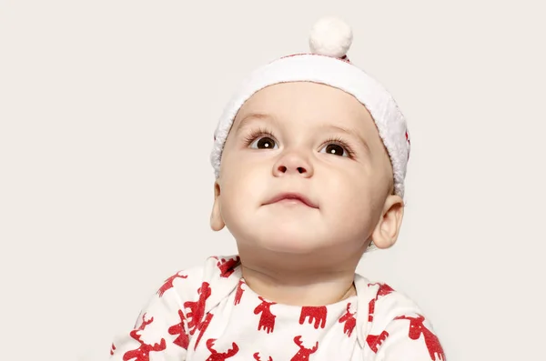 Noel Baba şapkası giyen düşünerek arıyorsunuz bir şirin bebek çocuk portresi. Stok Resim
