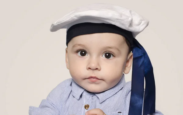 Bir denizci şapkası kameraya bakarak bir şirin bebek çocuk portresi. Stok Fotoğraf