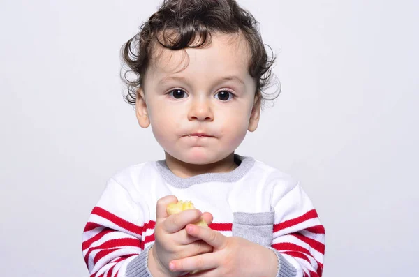 Portrait of a cute baby eating a banana. — Stock Photo, Image