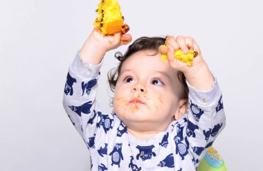 Bir yaşındaki çocuk şut pasta bir dilim başına yemek.
