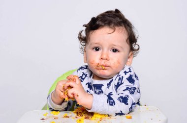 Bir yaşındaki çocuk şut pasta bir dilim başına yemek.