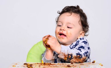 Bir yaşındaki çocuk şut pasta bir dilim başına yemek.