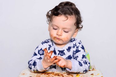 Bir yaşındaki çocuk şut pasta bir dilim başına yemek.