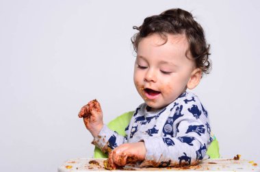 Bir yaşındaki çocuk şut pasta bir dilim başına yemek.