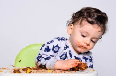 Bir yaşındaki çocuk şut pasta bir dilim başına yemek.