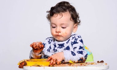 Bir yaşındaki çocuk şut pasta bir dilim başına yemek.