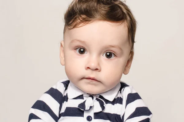 Retrato de un lindo bebé mirando a la cámara con sus grandes ojos . — Foto de Stock