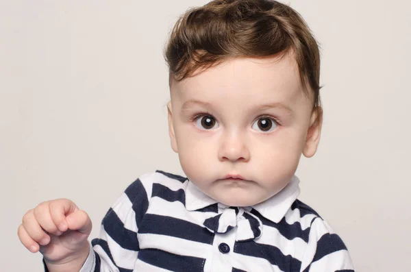 Portrait d'un mignon bébé garçon regardant la caméra avec de gros yeux curieux . — Photo