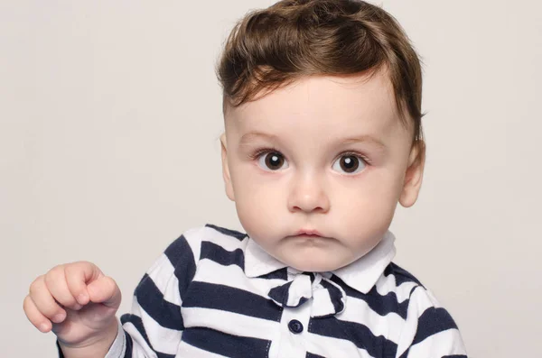 Retrato de um menino bonito olhando para a câmera com grandes olhos curiosos . — Fotografia de Stock