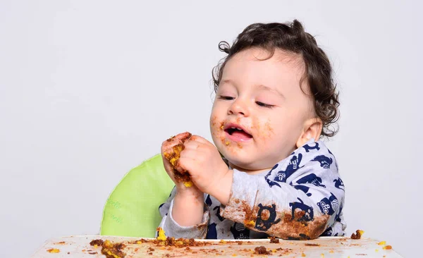 Un niño de un año comiendo una rebanada de pastel de cumpleaños solo. . — Foto de Stock