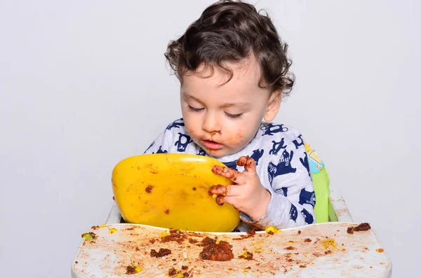 Um ano de idade criança comendo uma fatia de bolo de quebra de aniversário por si mesmo . — Fotografia de Stock