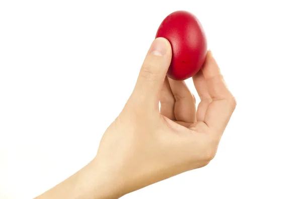 Onherkenbaar vrouw hand houden voor ei kloppen een rode Easter egg. — Stockfoto