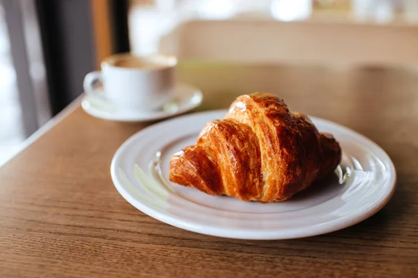 Notebook, cappuccino en croissant. — Stockfoto