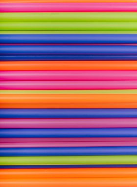 meyve suyu için renkli borular ve pembe arka planda kokteyller.