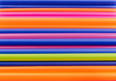 meyve suyu için renkli borular ve pembe arka planda kokteyller.