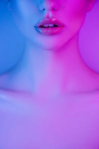Renkli parlak neon mavi ve mor ışıklar yüksek moda modeli dudaklar kadın, güzel kız yakın çekim yüz — Stok fotoğraf
