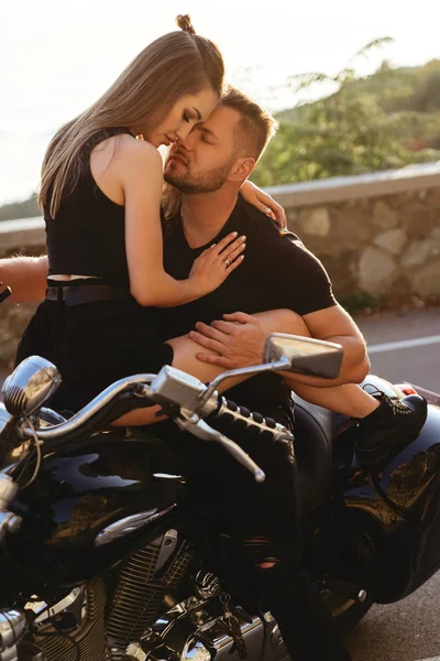 Bir çift aşık motosiklette öpüşüyor ve sarılıyor.