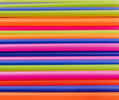 meyve suyu için renkli borular ve pembe arka planda kokteyller.