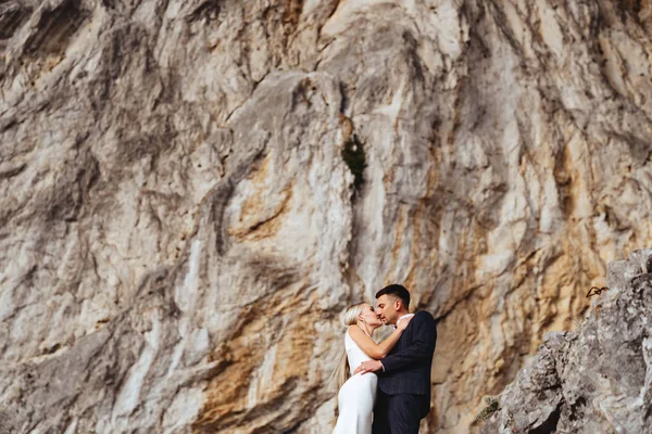 Młoda para nowożeńców, narzeczona i pan młody całujący się, przytulający się na doskonały widok na góry — Zdjęcie stockowe
