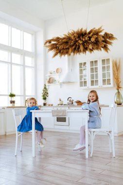 Mutfak masasında oturan iki çocuk..