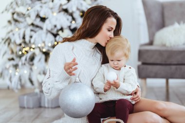 Mutlu anne ve bebeğin portresi süslenmiş Noel ağacı