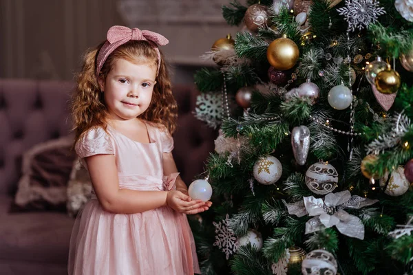 Happy child girl near a Christmas tree — Stock Photo, Image