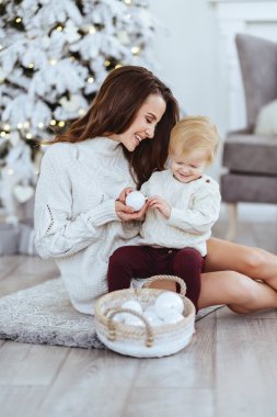 Mutlu anne ve bebeğin portresi süslenmiş Noel ağacı