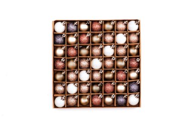 Altın Noel süslemeleri beyaz arka planda kutuda.