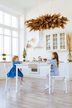 Mutfak masasında oturan iki çocuk..