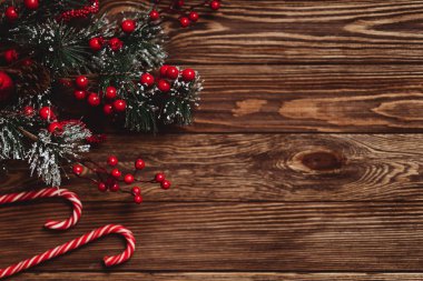 Mavi ahşap arka planda Noel süslemeleri olan fidan dalları.