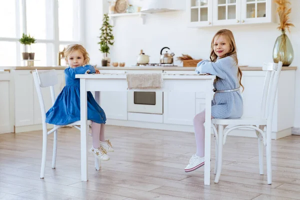 Dwoje dzieci siedzących na stole kuchennym. — Zdjęcie stockowe