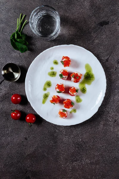 Three stuffed tomatoes on a white plate