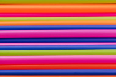 meyve suyu için renkli borular ve pembe arka planda kokteyller.