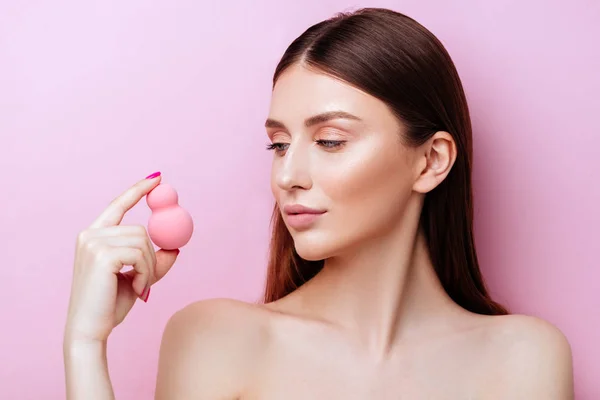 Funny girl holding pink sponge near her face. Portrait of young girl on pink background. — Stock Photo, Image