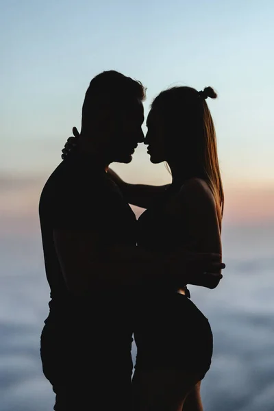 Casal feliz observando um ao outro sob o céu por do sol — Fotografia de Stock