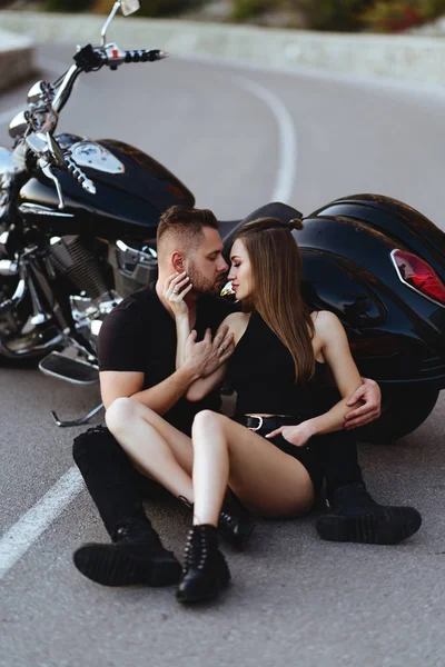 Bir çift aşık motosiklette öpüşüyor ve sarılıyor.