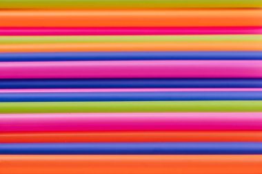 meyve suyu için renkli borular ve pembe arka planda kokteyller.