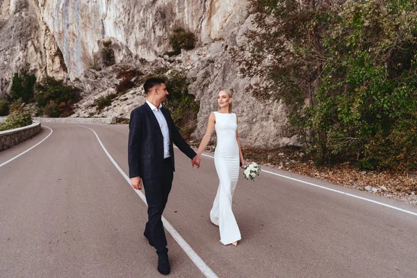 Jeune couple nouvellement marié, mariée et marié baisers, câlins sur la vue parfaite sur les montagnes — Photo