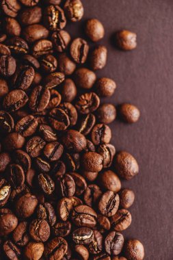 Kahve taneleri. Kavrulmuş kahve çekirdekleri kahverengi arka plan. Düzen.