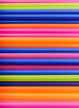 meyve suyu için renkli borular ve pembe arka planda kokteyller.