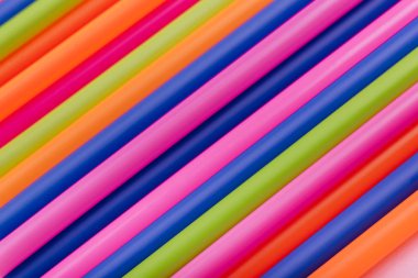 meyve suyu için renkli borular ve pembe arka planda kokteyller.