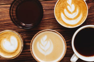 Eski ahşap üzerine beş fincan kahve. Üst manzara, tahta masada fincan..