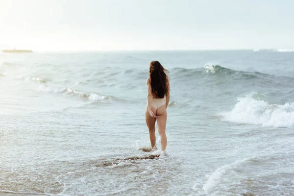 푸른 바다 뒤에 누워 있는 비키니를 입고 있는 여자 — 스톡 사진
