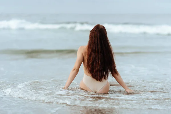 Mulher de biquíni posando atrás do oceano azul — Fotografia de Stock