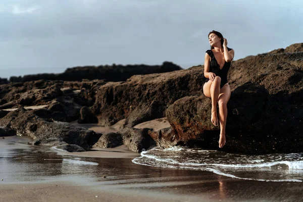 Retrato de mulher bonita moda esporte em biquíni preto posando no verão perto do oceano — Fotografia de Stock