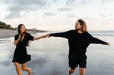 Çekici erkek ve kadın gün batımında romantik bir akşam geçiriyorlar.